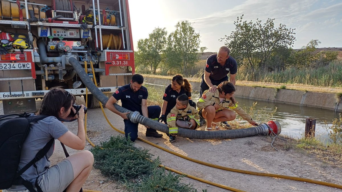 La fotoperiodista Laia Pedrós, a la izquierda, fotografiando a los bomberos con Santino y Josefina. - BOMBERS AMB CAUSA