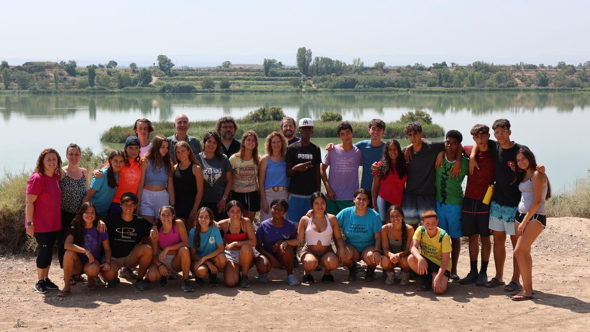 Els joves participants en aquestes activitats d’estiu, amb les autoritats ahir a l’estany. - J.GÓMEZ