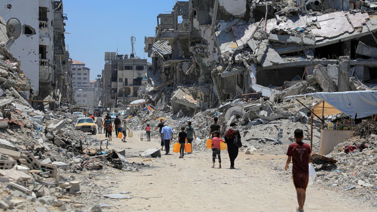 Palestinos caminan entre los restos de edificios en ruinas por ataques israelíes en Jan Yunis. - EUROPA PRESS