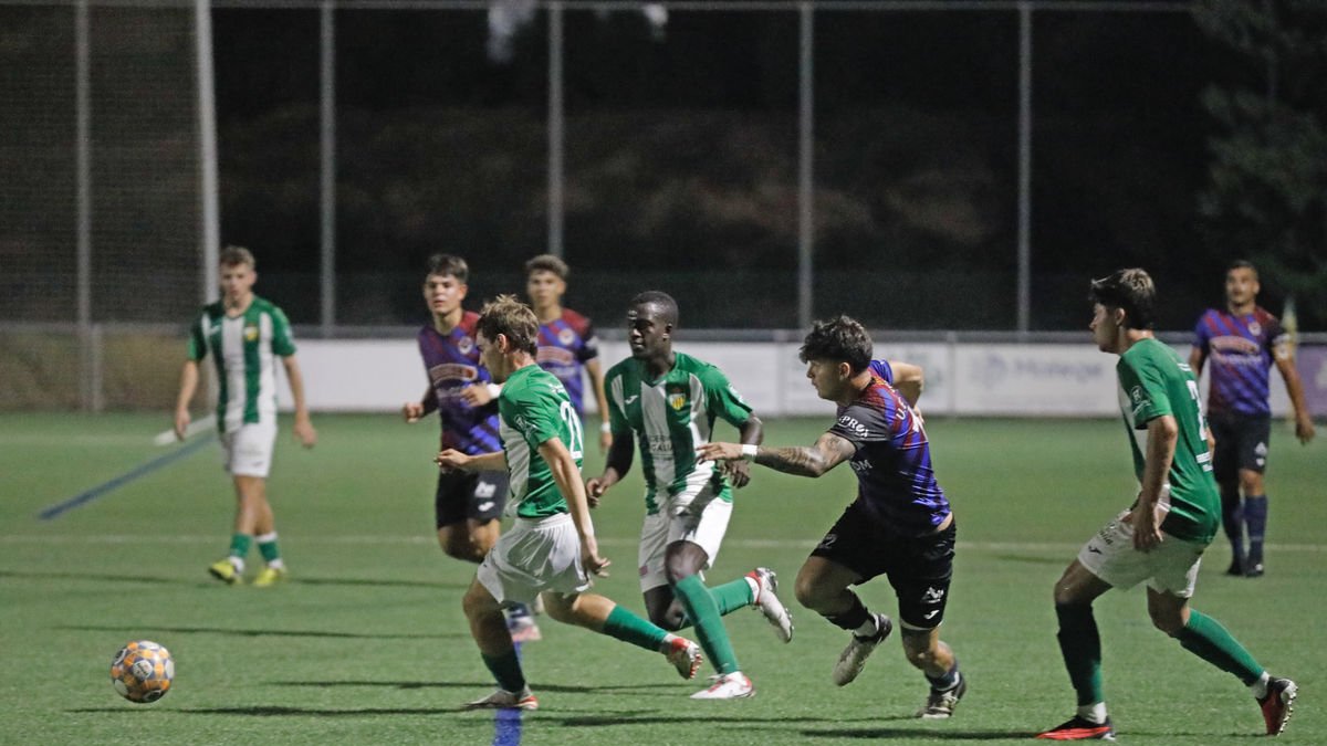 Un jugador de l’Alguaire intenta aconseguir el control de la pilota, davant la mirada dels rivals. - AMADO FORROLLA