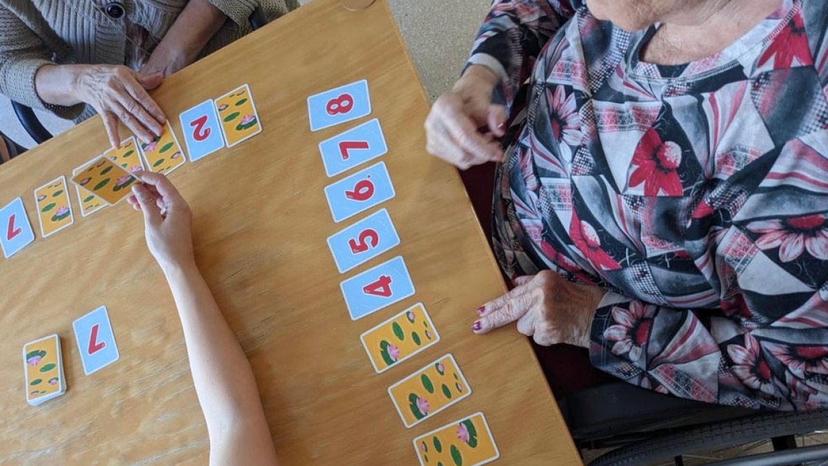 Residentes jugando a un juego de cartas con números. - NEUROPGA