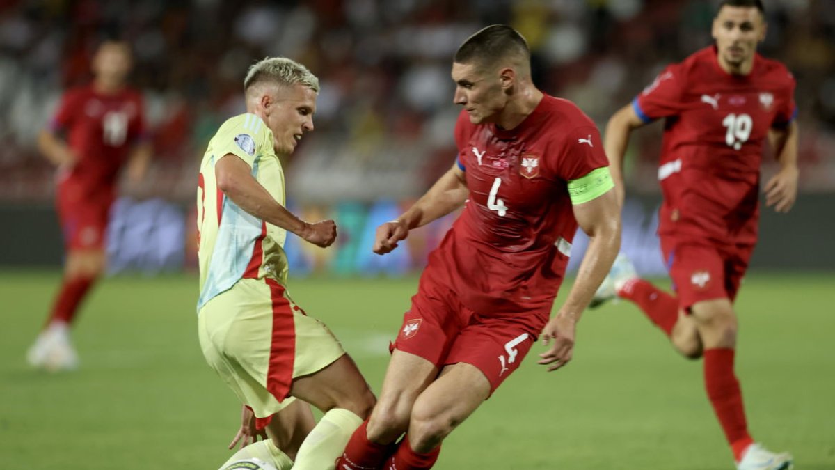 Dani Olmo recibe una entrada del capitán serbio Nikola Milenkovic, ayer durante el partido. - EFE/EPA/ANDREJ CUKIC