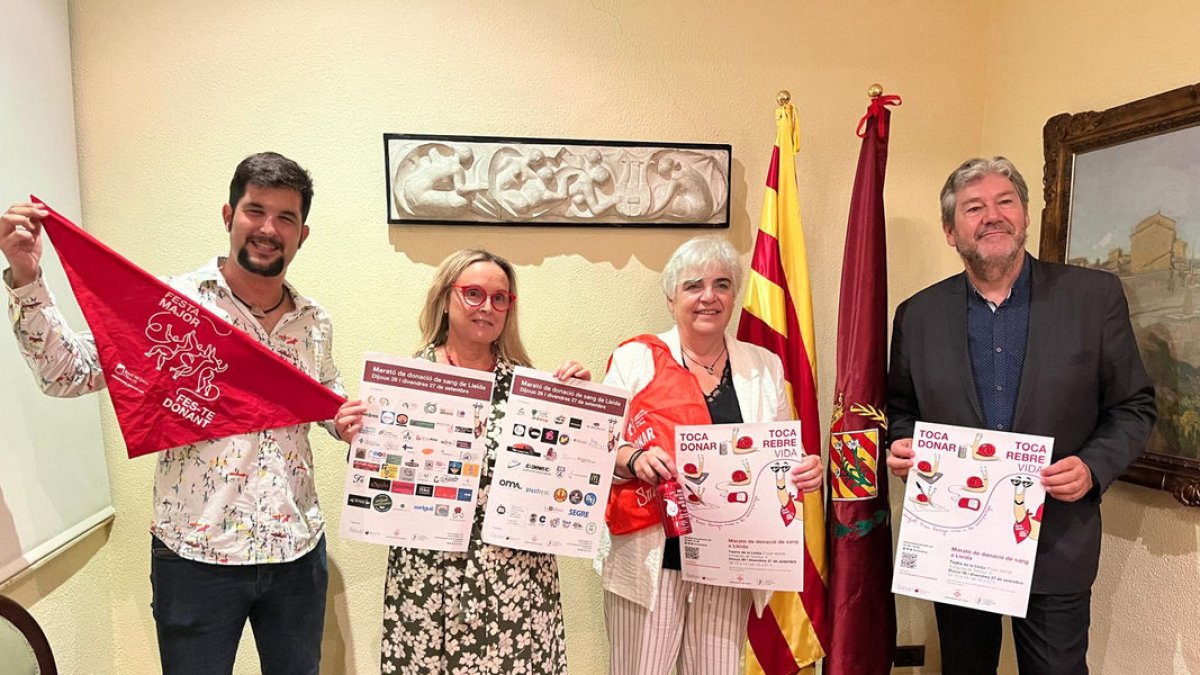 Responsables del Banc de Sang de Lleida y la Paeria con los carteles de la 21ª Marató de Sang.