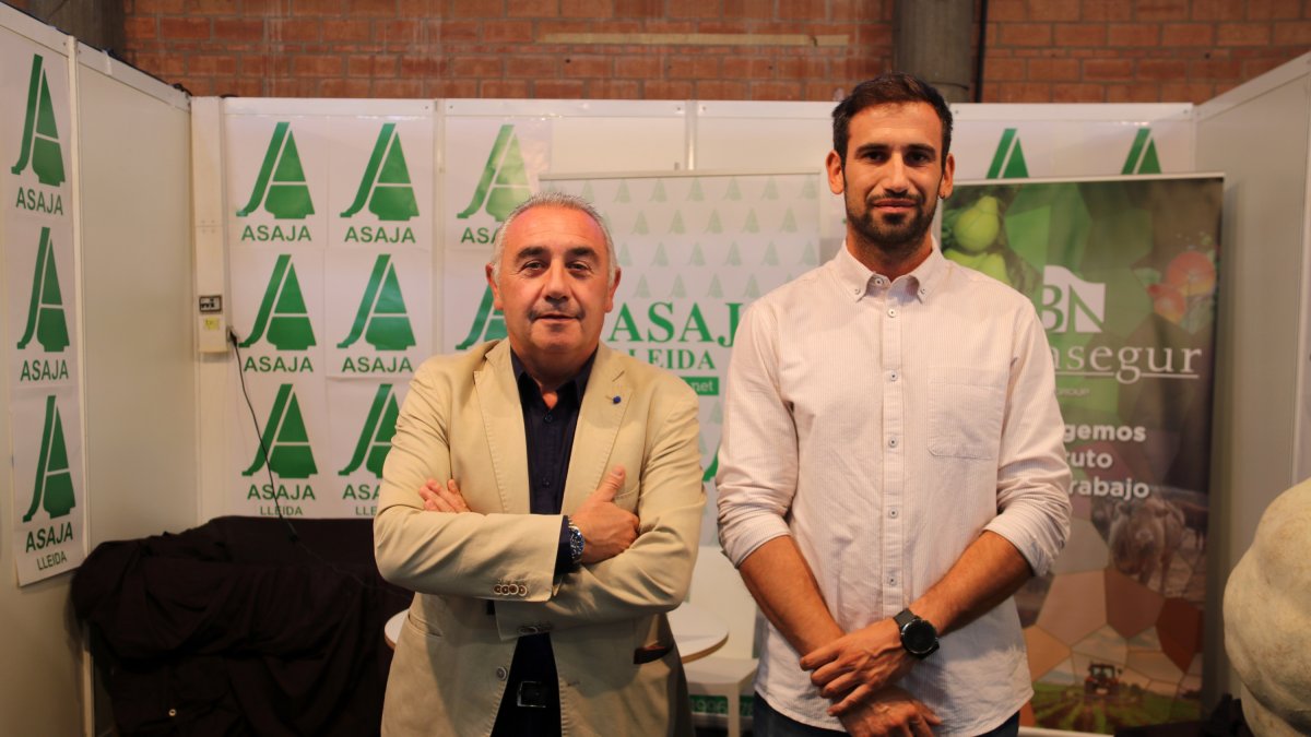 El president d'Asaja Lleida, Pere Roqué, i el responsable de Fruita Dolça del sindicat, Jordi Vidal, a l'estand d'Asaja a la Fira de Sant Miquel de Lleida