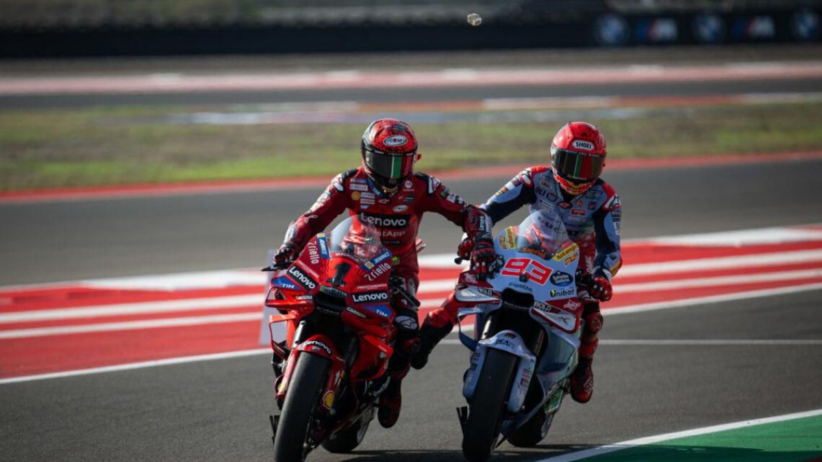 Bagnaia posa la mà sobre la moto de Marc per remolcar-se.