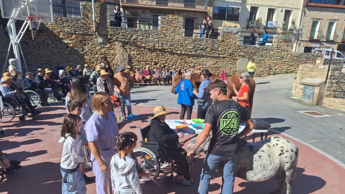 Els usuaris amb els ponis i el cavall ahir a la plaça del centre de gent gran, amb els nens i els voluntaris de l’hípica. - AJUNTAMENT D’ÀGER
