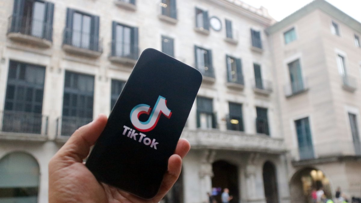 En primer terme, un mòbil amb el logotip de Tik Tok.