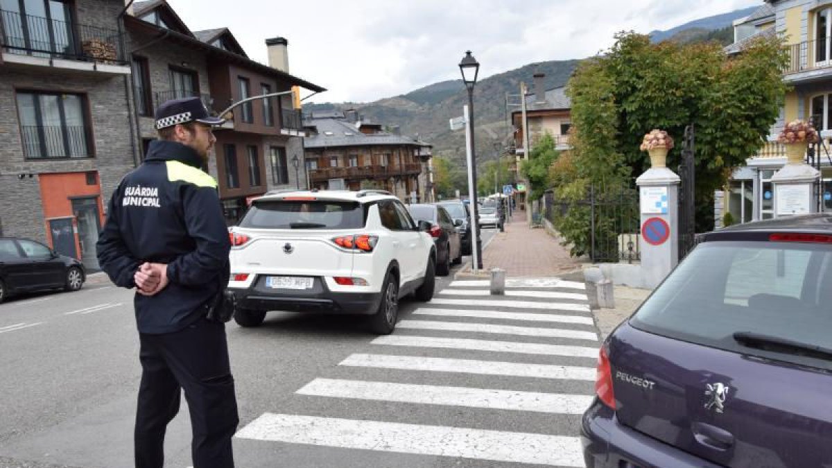 El agente municipal controla el estacionamiento de vehículos. - C.SANS