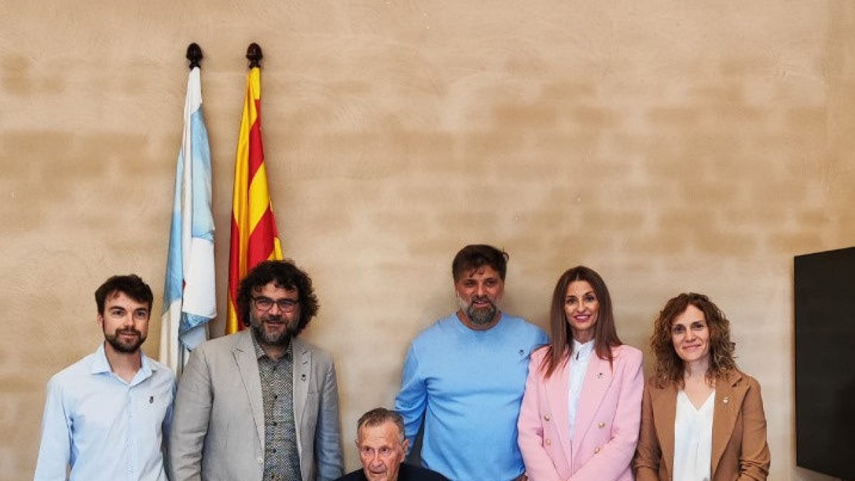 Ignasi Madir, sentado, tras firmar en el libro de honor.