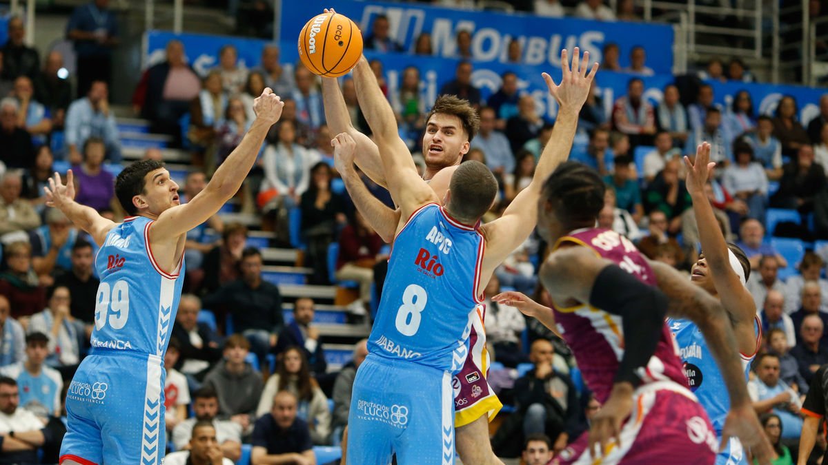 Rafa Villar intenta hacer un pase entre los brazos de dos rivales. - ACB PHOTO