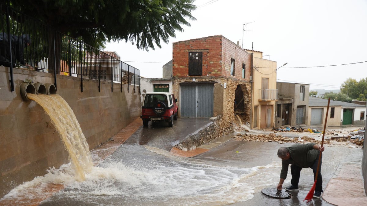 Un home aixeca la tapa d’una claveguera perquè pugui absorbir més aigua a Castelló. - EFE
