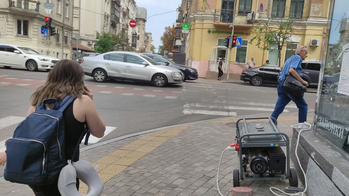 Residentes en Kyiv pasan por delante de generadores eléctricos. - EFE/MARCEL GARCÓN