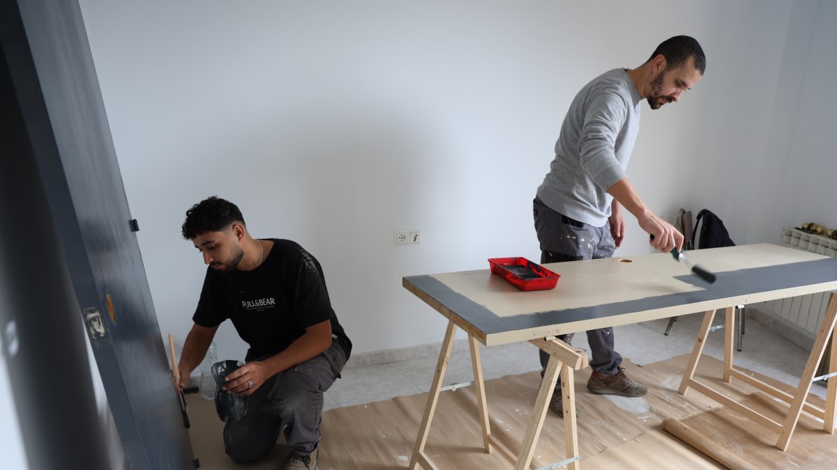 Dos jóvenes pintando una de las viviendas.