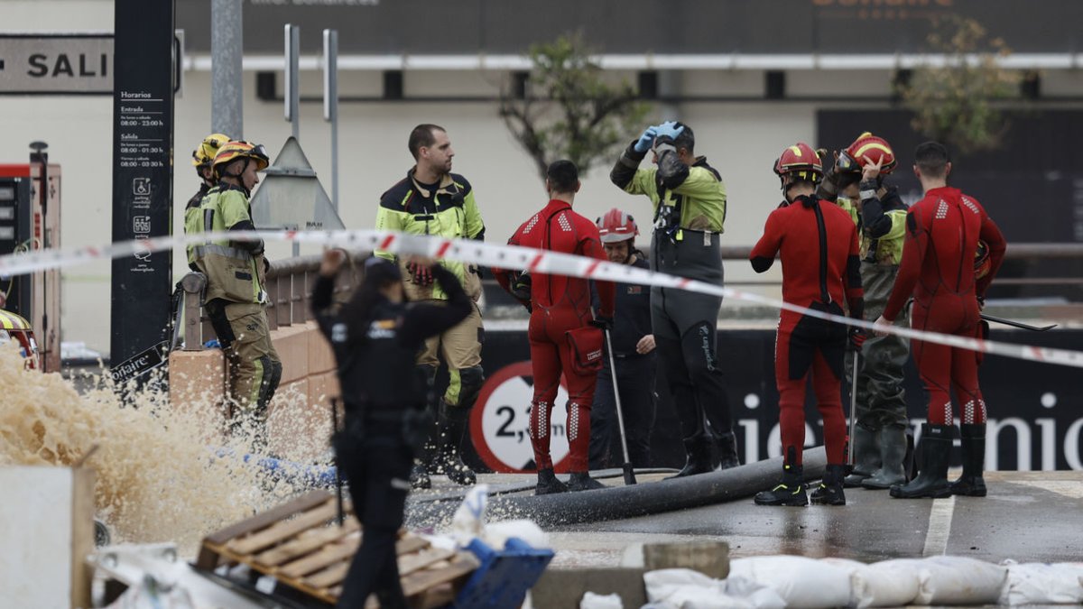 Bombers i Policia Nacional, ahir a la rampa d’accés al pàrquing subterrani del centre comercial d’Aldaia. - EFE