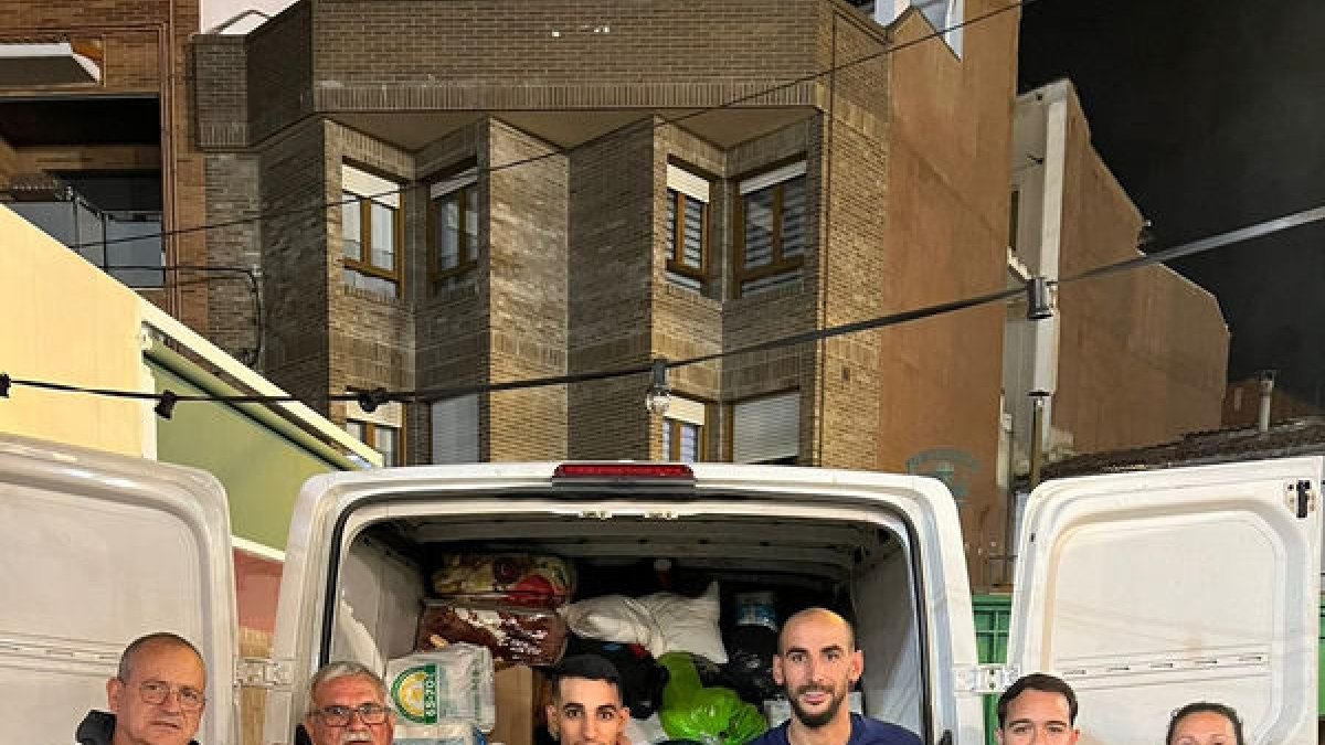 Directius posen davant d’una de les furgonetes.
