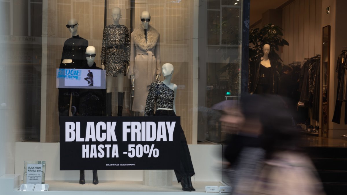 Diverses persones passen davant d’un comerç que anuncia descomptes. Eduardo Parra - Europa Press - Arxiu 