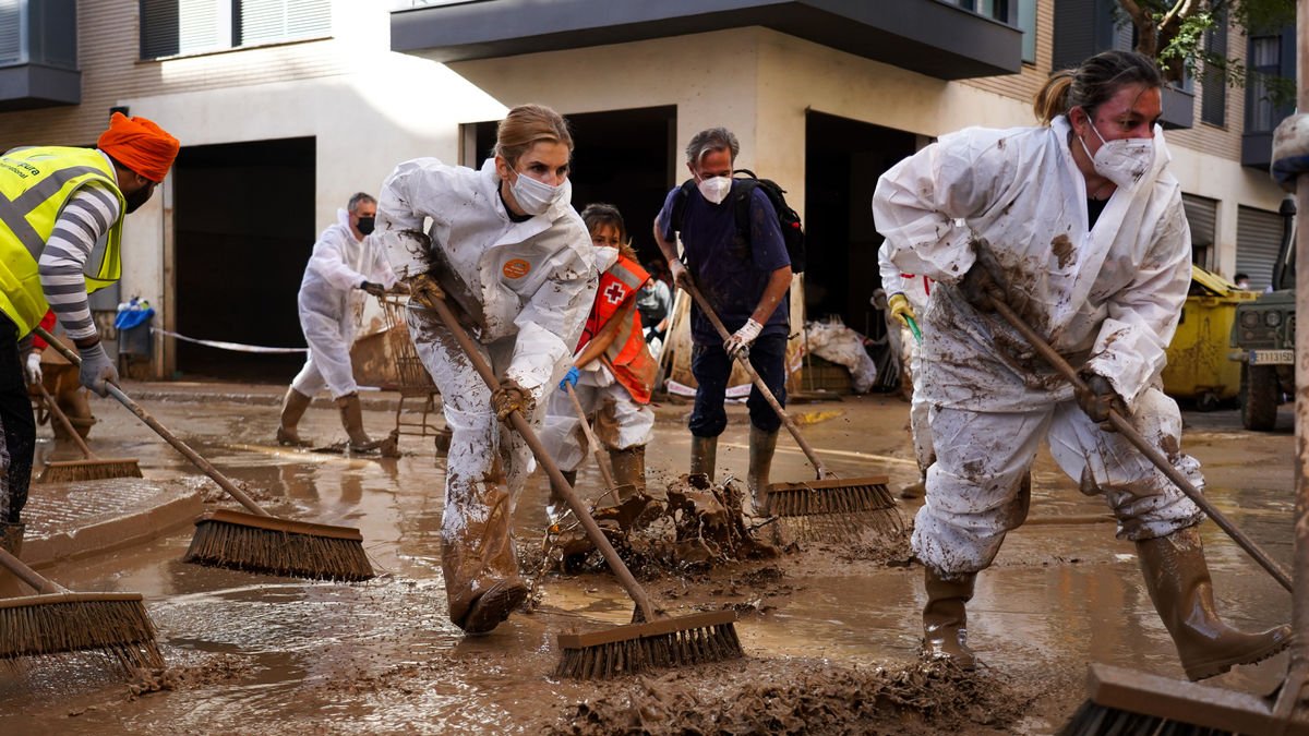 Vecinos limpiando ayer las calles que aún siguen cubiertas de agua y barro en Paiporta. - EUROPA PRESS