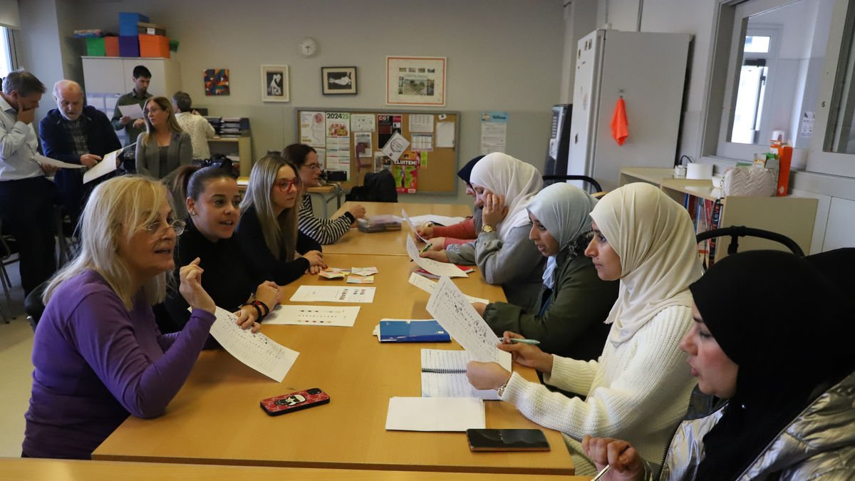 Un grup de mares d’alumnes i de voluntaris de ‘Vincles’, ahir a l’Escola Països Catalans. - MAGDALENA ALTISENT