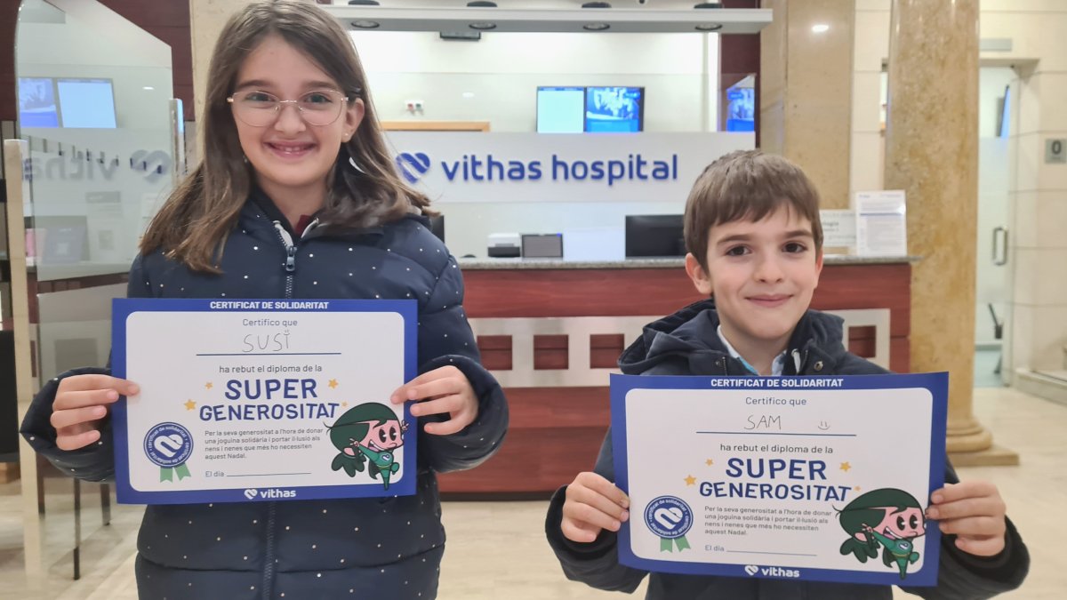 Dos nens amb el seu diploma de 'Super Generositat’ després de donar un regar-lo