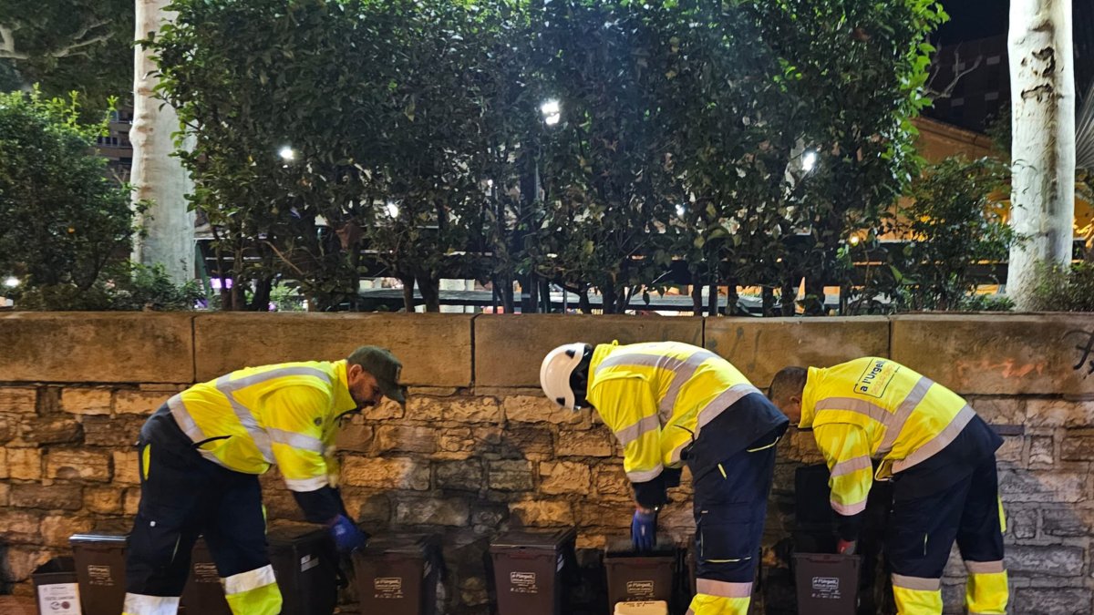 Personal coge las bolsas de basura de los nuevos cubos del sistema puerta a puerta parcial en Tàrrega.