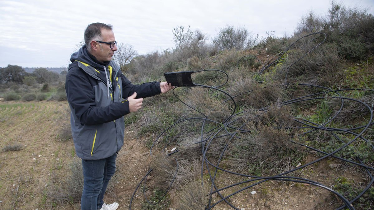 L’alcalde, Jordi Portí, mostrant un dels cables de fibra empalmats i trencat al mig d’un camp a prop de Granyanella. - C. MARSIÑACH