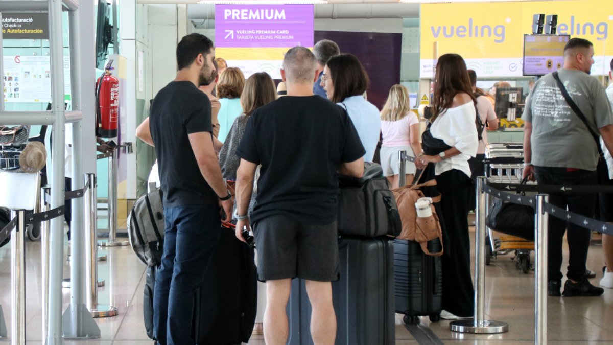 Cues de passatgers per embarcar les seves pertinences.