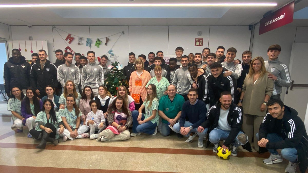 Els jugadors, tècnics i altres representants del Lleida CF posen amb personal i nens a l’Arnau de Vilanova. - LLEIDA CF