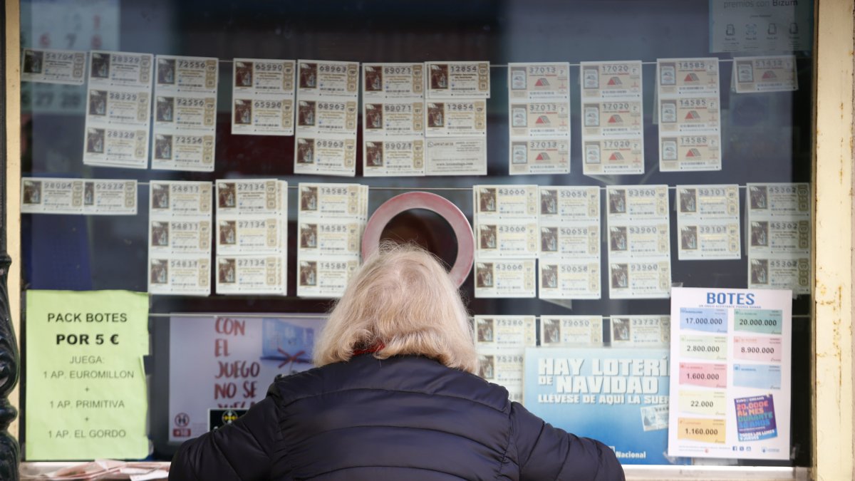 Una persona compra loteria en un punt de venda.