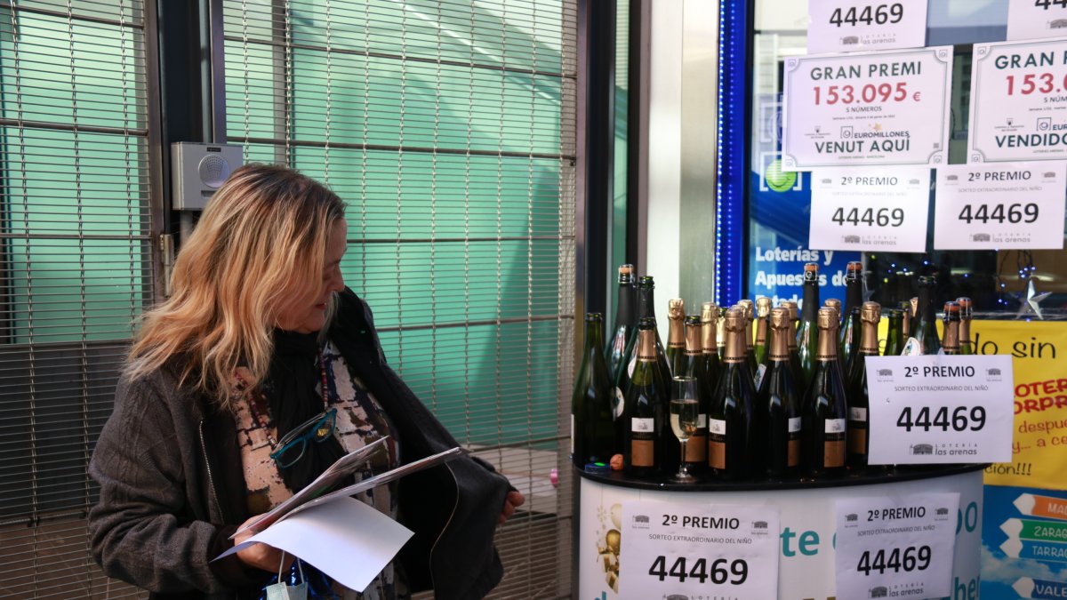 Una treballadora de l'adminstració de loteria del centre comercial Arenas de Barcelona preparant ampolles de cava per celebrar que el local ha repartit un premi del Nen en una imatge d'arxiu.