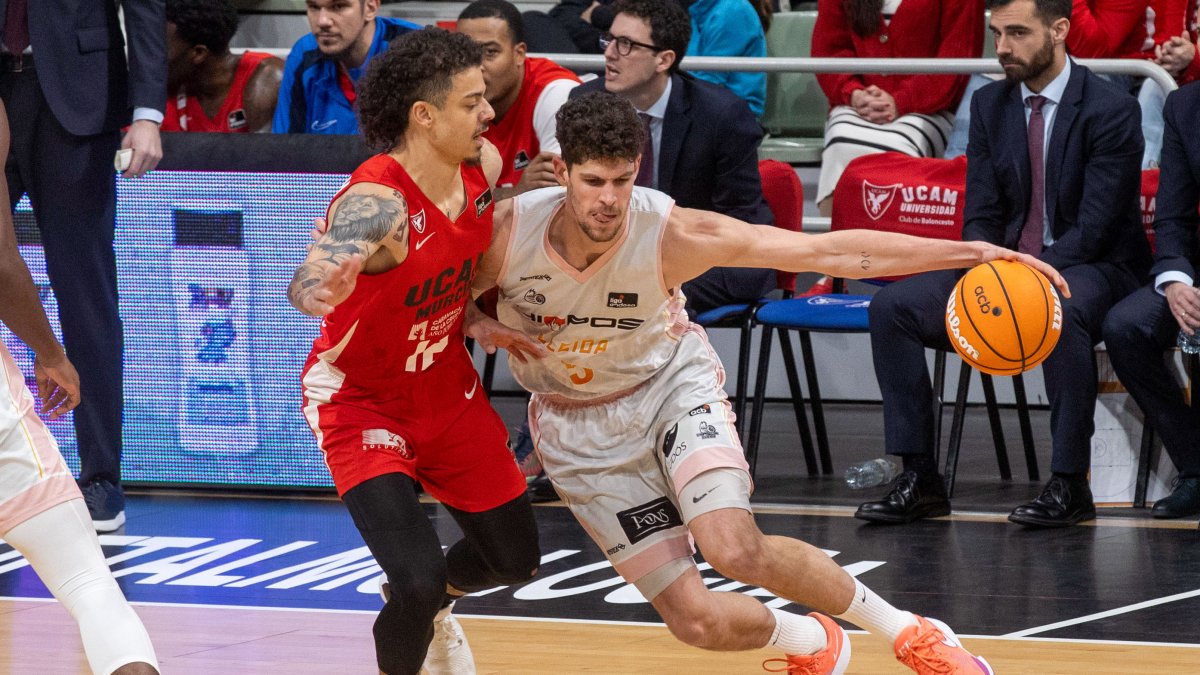 L’aler|ràfec de Hiopos Lleida Oriol Paulí (d), controla la pilota davant de la pressió de l’ala base nord-americana d’UCAM Jonah Radebaugh (i).