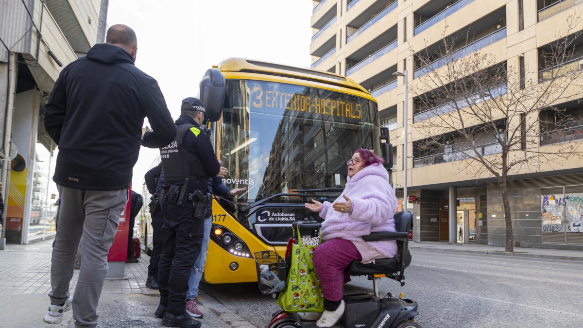 Carla García parla amb un agent de la Guàrdia Urbana mentre bloqueja la circulació de l’autobús