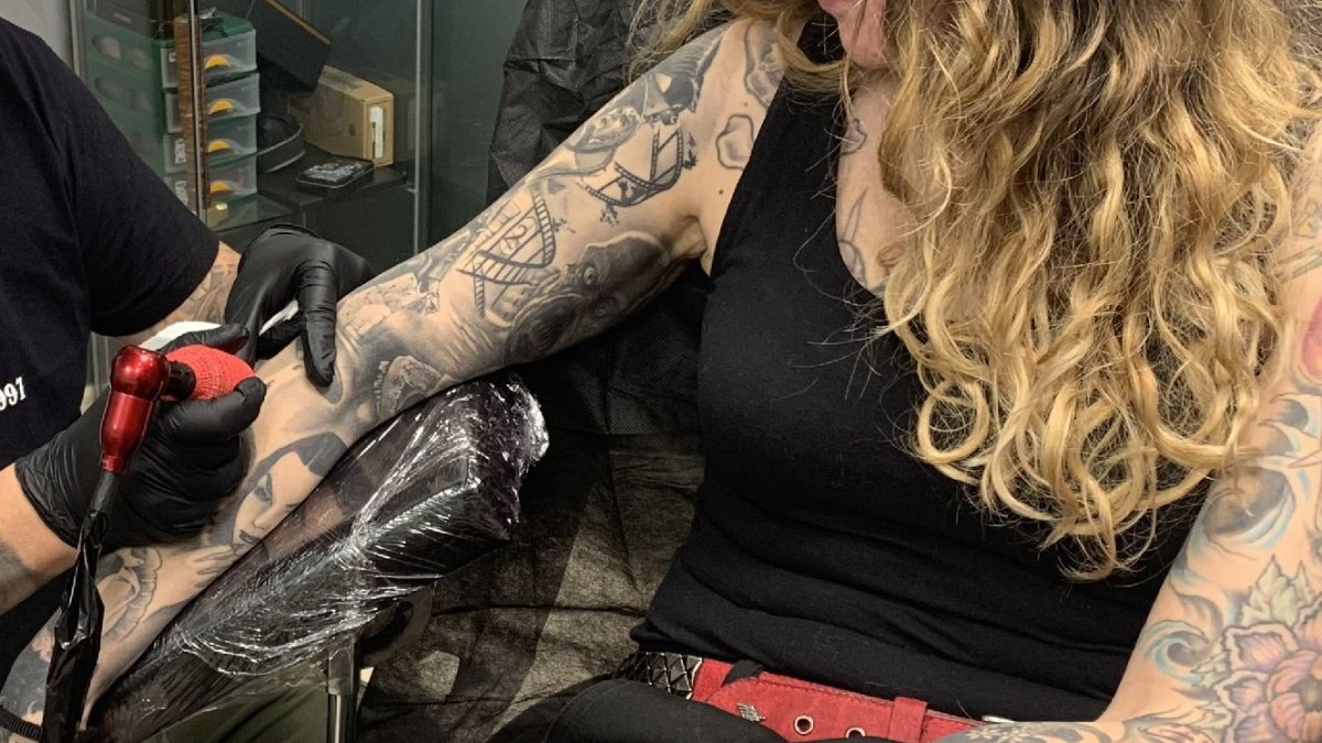 Un professional realitza un tatuatge.