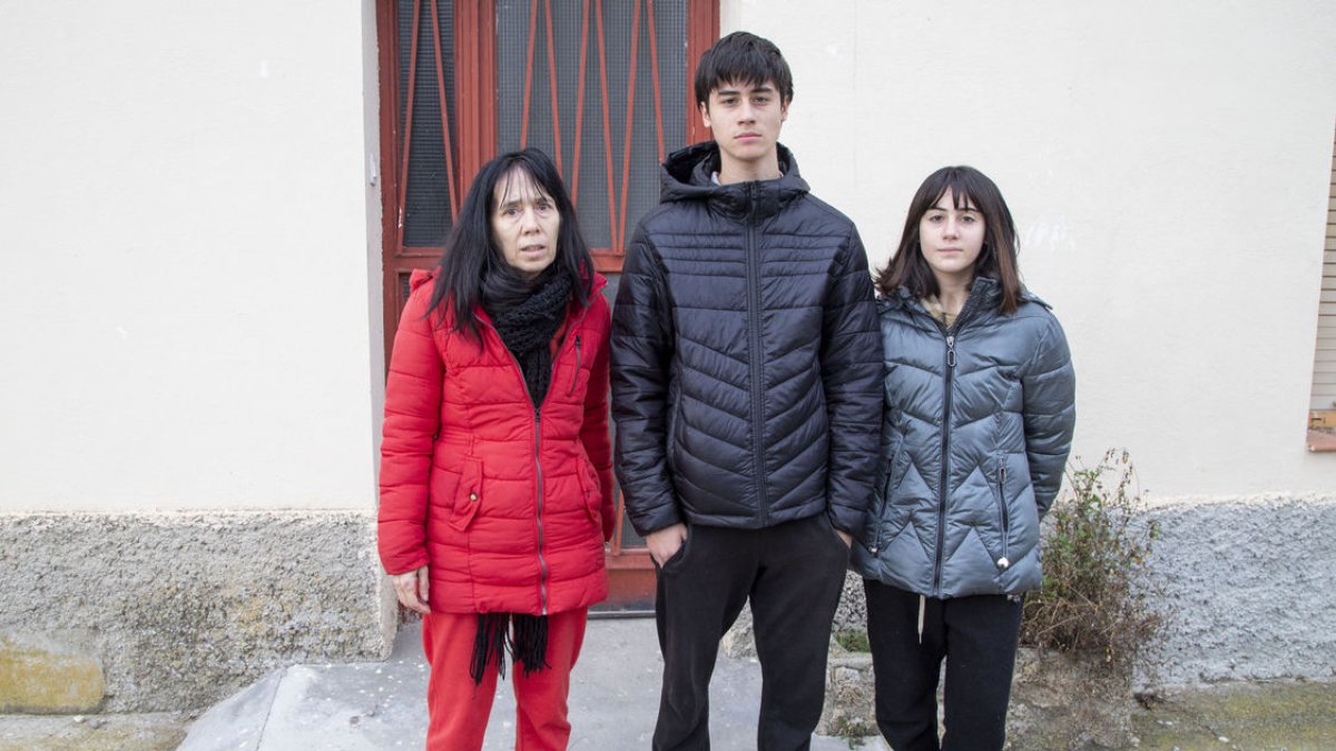 Tres dels quatre membres de la família a la porta de la casa en la qual viuen des de finals del 2021. - LAIA PEDRÓS