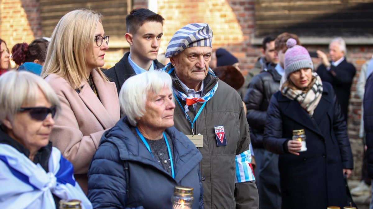 Supervivientes del campo de concentración y de exterminio nazi de Auschwitz y sus familiares depositan velas frente al emblemático 