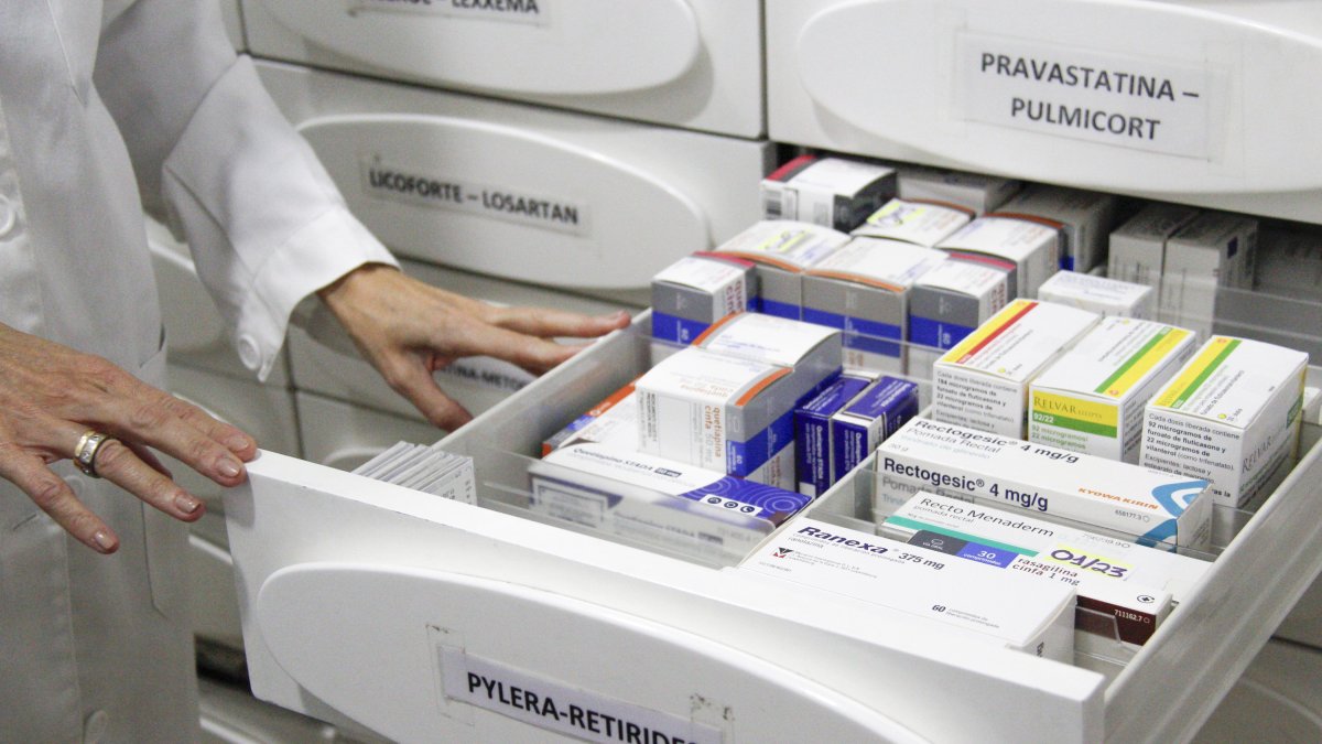 Una farmacèutica mostra diversos medicaments.