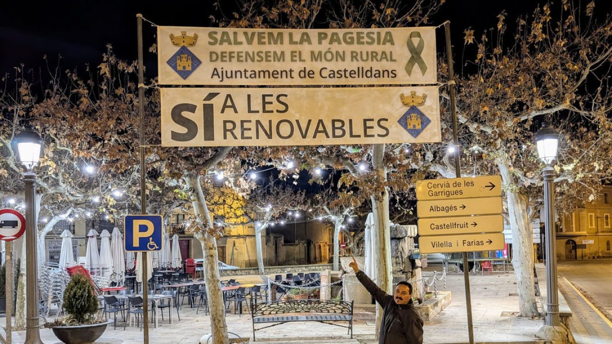 El alcalde de Castelldans, Conrad Llovera, ante la pancarta en favor de las renovables. - AJUNTAMENT DE CASTELLDANS