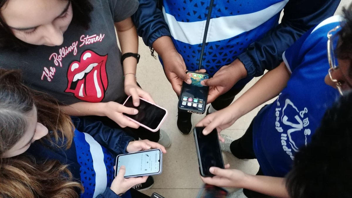 Alumnos de ESO de un instituto de Lleida mostrando los teléfonos móviles. - S.E.