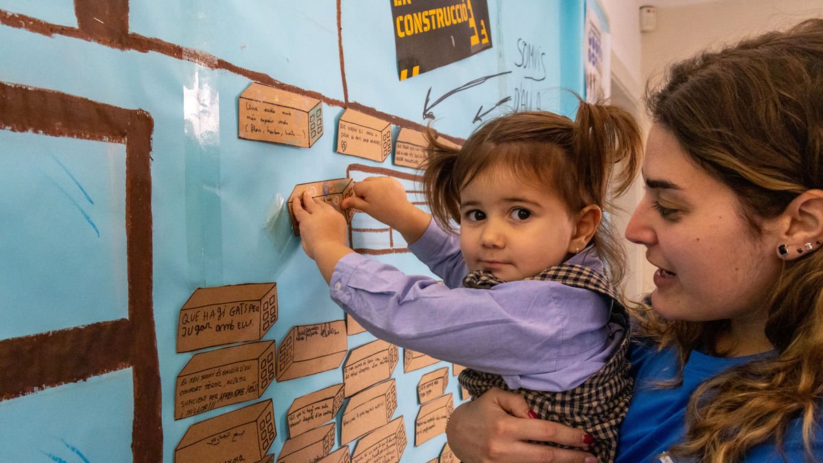 Una niña coloca un ladrillo con su “sueño” para el colegio. - ROGER BARRAGÁN