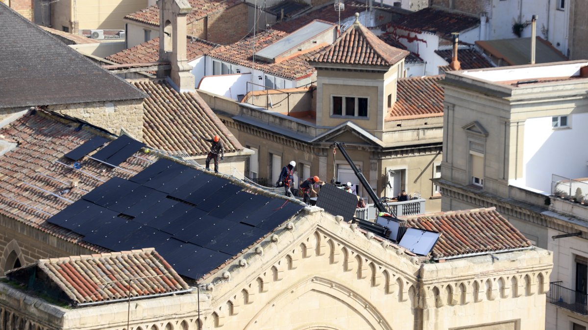 Operaris instal·laven ahir les plaques a la coberta de l’església de Sant Joan. - MAGDALENA ALTISENT