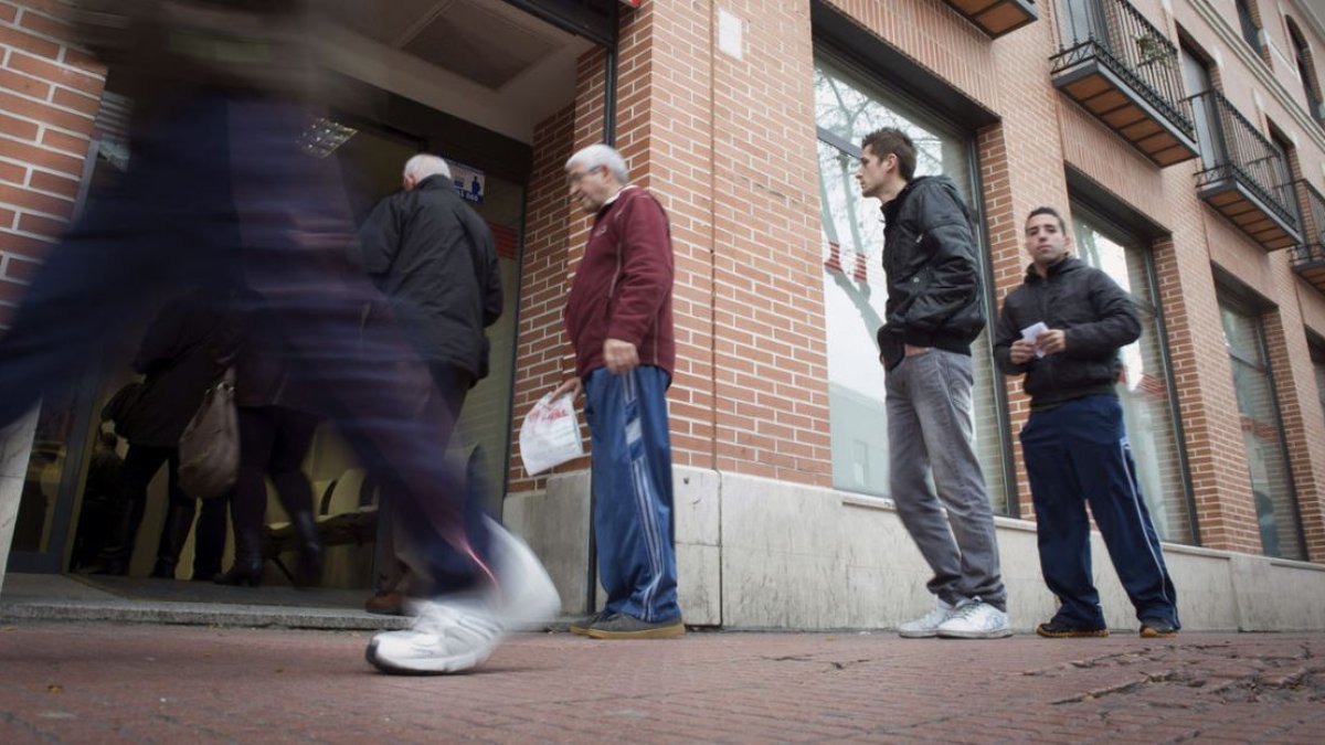 Imatge d’arxiu d’aturats fent cua en una oficina per registrar-se com a parats. - EFE