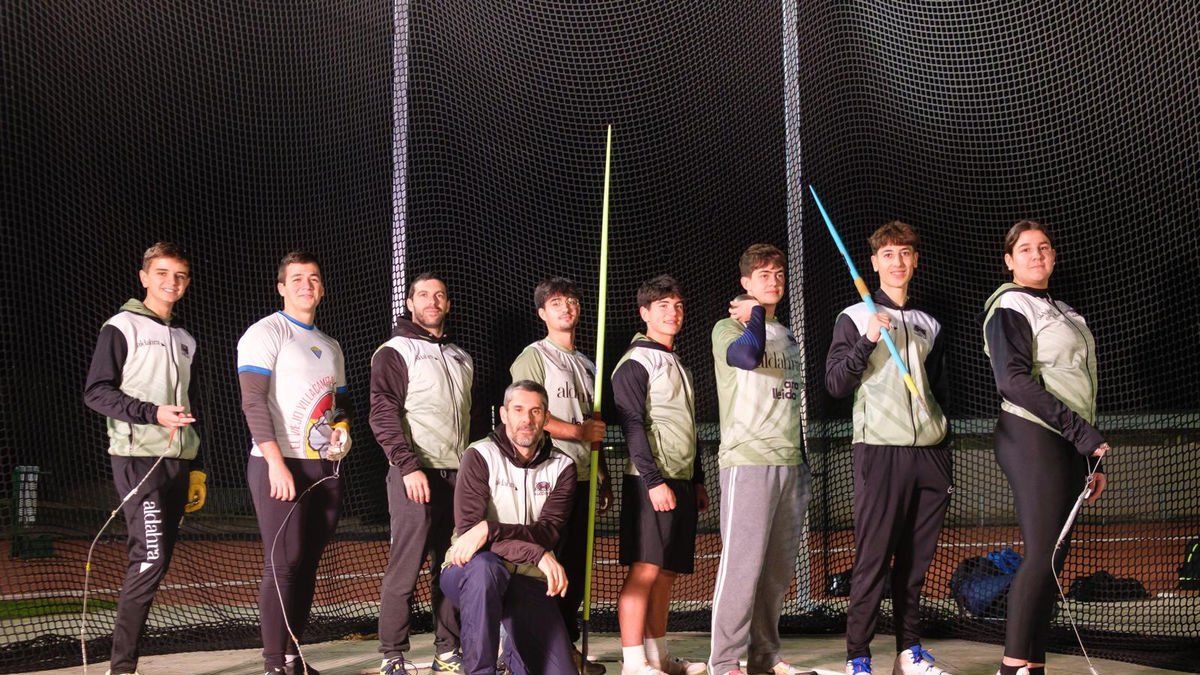 David Rubio, agachado, con algunos de los atletas del grupo de lanzadores con los que trabaja en la pista de Les Basses.