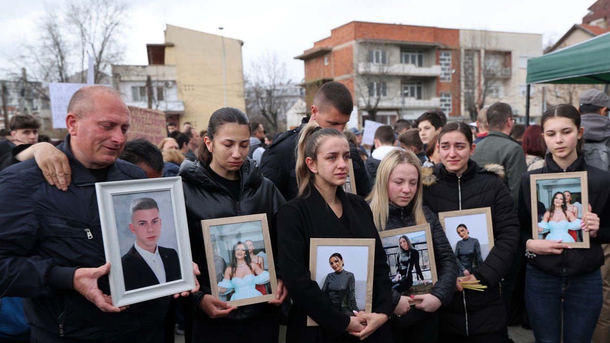 Familiares con fotos de sus seres queridos muertos en el incendio durante una protesta en Skopie. - EFE/EPA/GEORGI LICOVSKI