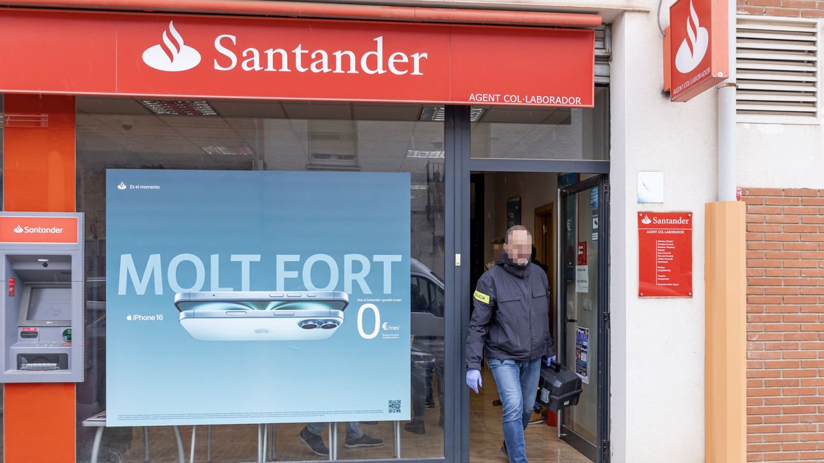 Un investigador de los Mossos d’Esquadra saliendo el martes de la oficina asaltada. - JORDI ECHEVARRIA