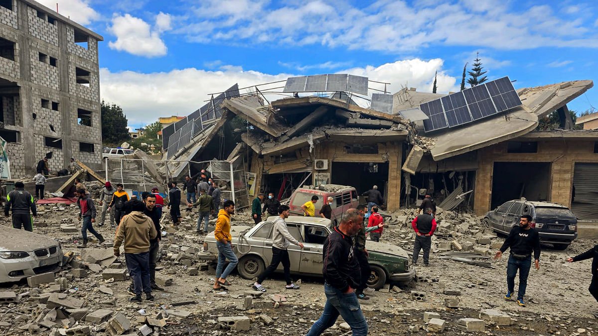 Libanesos inspeccionen la destrucció d’un edifici blanc d’un atac aeri israelià. - STR / DPA