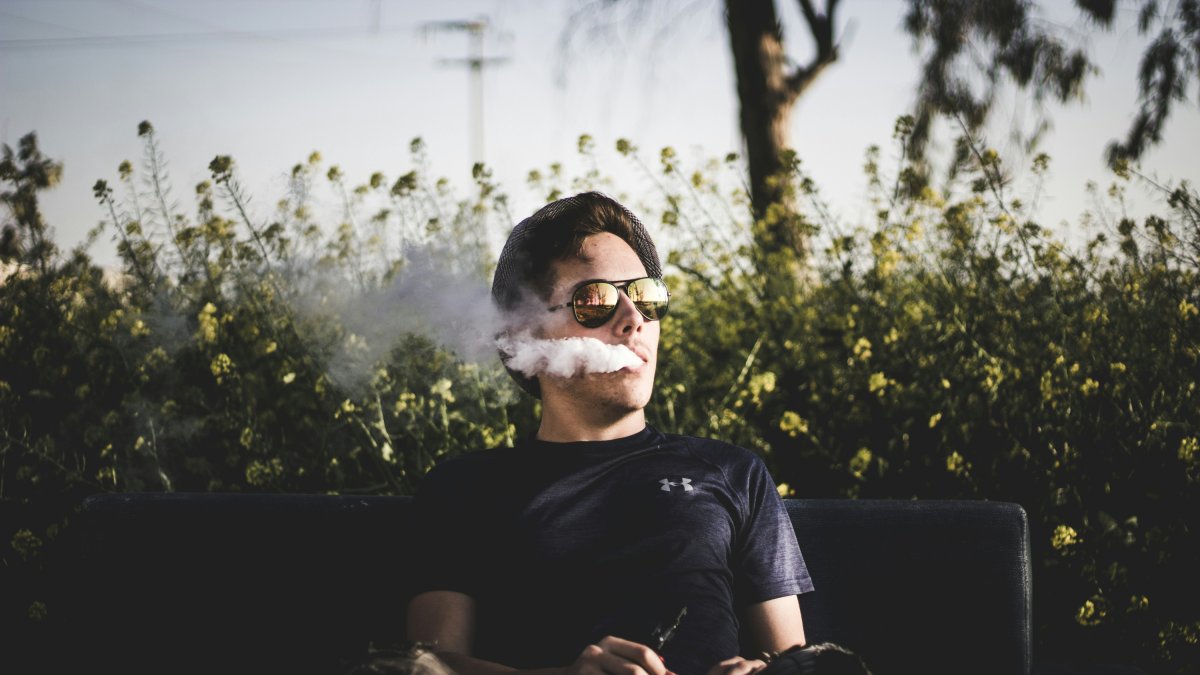 Un hombre fumando un cigarrillo electrónico.