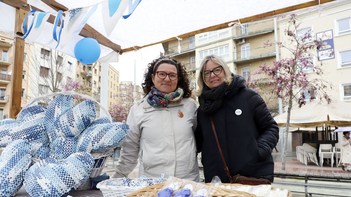 Dos voluntarias ayer en la mesa informativa instalada en la plaza Ricard Viñes. - MAGDALENA ALTISENT