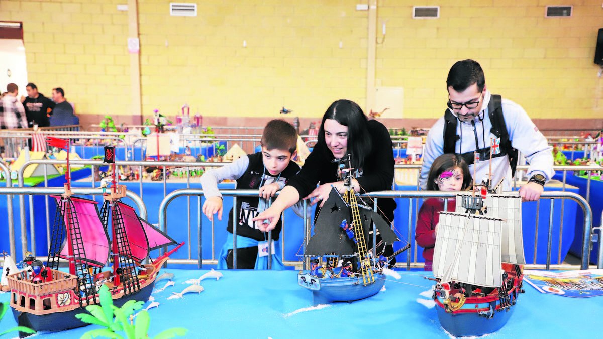 Una familia junto a una de las maquetas de Playmobil expuestas en Torre-serona. - MAGDALENA ALTISENT