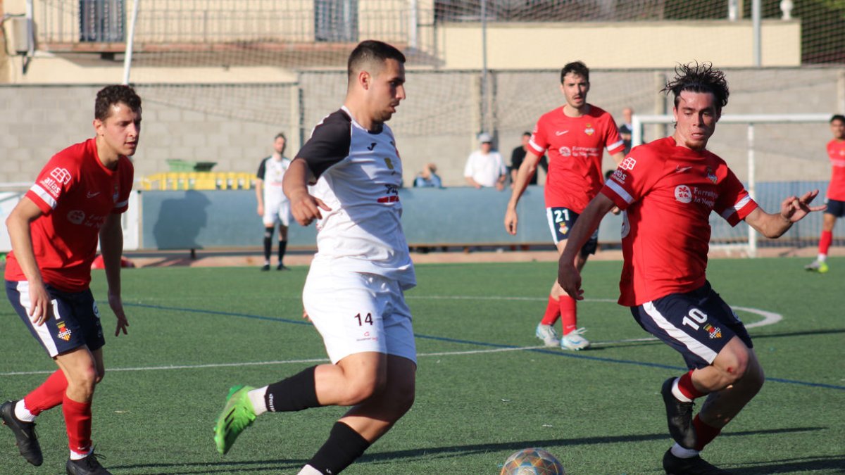 Un jugador del Borges intenta controlar la pilota davant de la pressió de dos del Balaguer. - JOAN BOVÉ