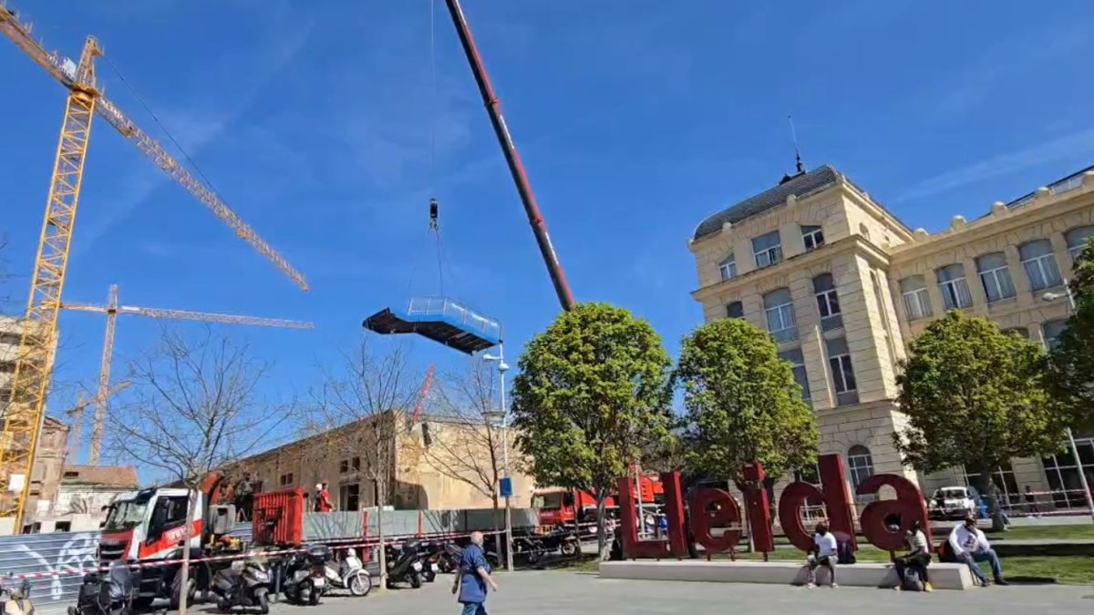 Una gran grua retira les escales del pas elevat de l'estació de tren de Lleida