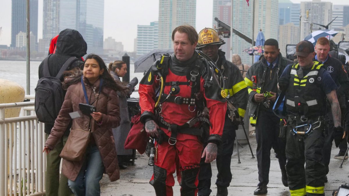 Buzos de los Bomberos de Nueva York regresan al muelle tras buscar entre los restos del aparato. - MILO HESS / ZUMA PRESS / CONTACTOPHOTO